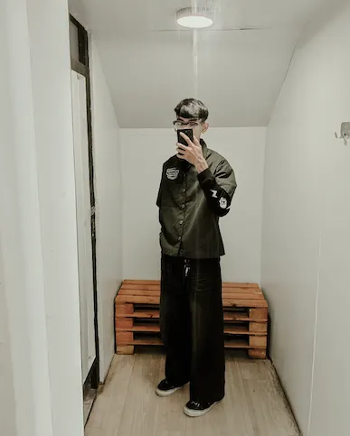 Pria dengan jaket hijau army di dalam ruangan