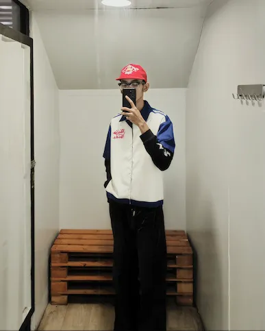 Pria dengan jaket putih dan helm di dalam ruangan